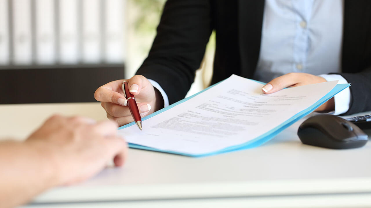 Close up of person gesturing signature line on a document