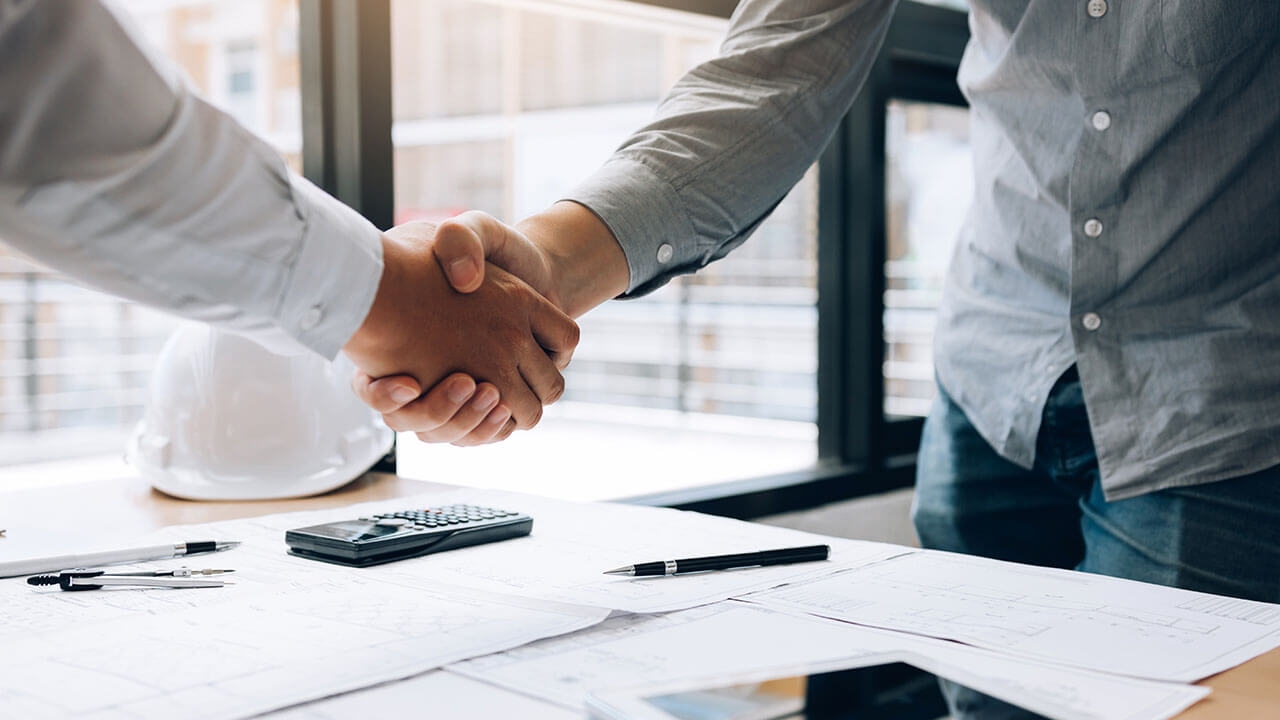 Close up of two people shaking hands in office